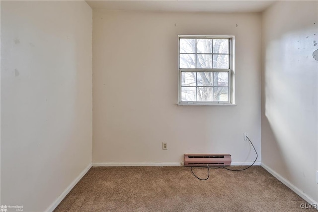 carpeted spare room featuring a baseboard heating unit