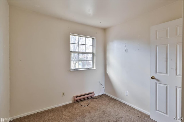 empty room featuring a baseboard heating unit and light colored carpet