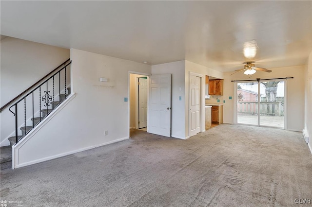 unfurnished living room featuring light carpet and ceiling fan