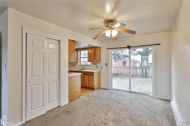 kitchen with sink, light carpet, and ceiling fan