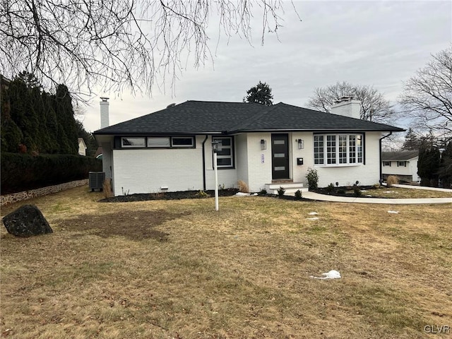 ranch-style house with central AC unit and a front lawn