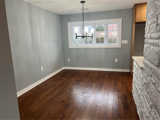 unfurnished dining area featuring dark hardwood / wood-style floors and a chandelier