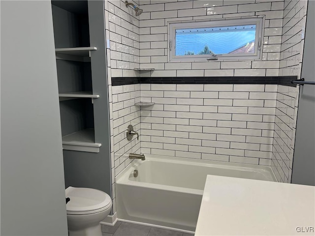 bathroom with tiled shower / bath, tile patterned floors, and toilet