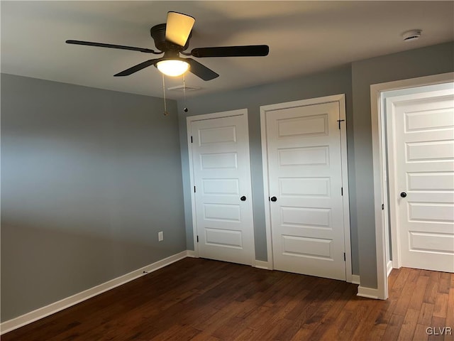 unfurnished bedroom featuring ceiling fan and dark hardwood / wood-style flooring