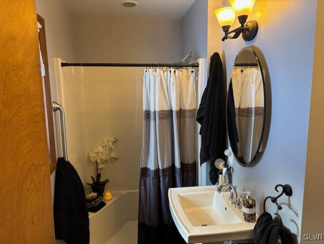 bathroom with shower / bath combination with curtain and sink