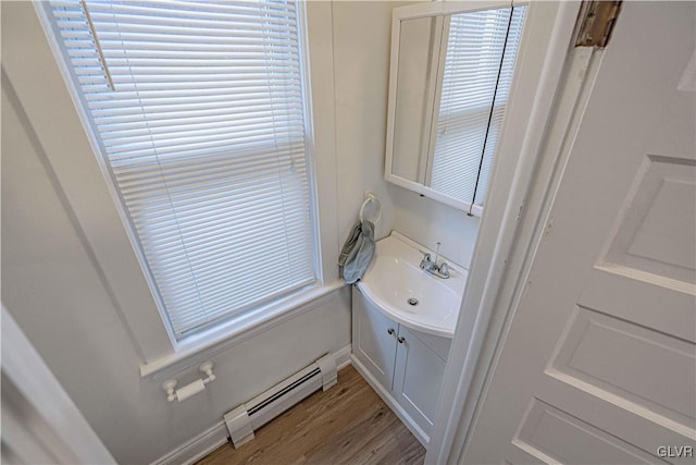 bathroom with hardwood / wood-style flooring, vanity, and a baseboard heating unit