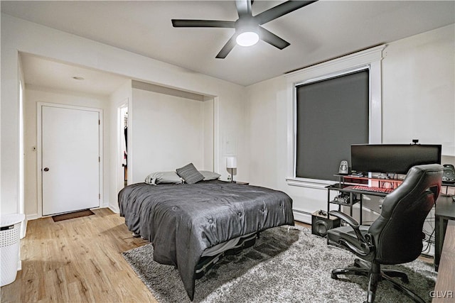 bedroom featuring baseboard heating, ceiling fan, and light wood-type flooring