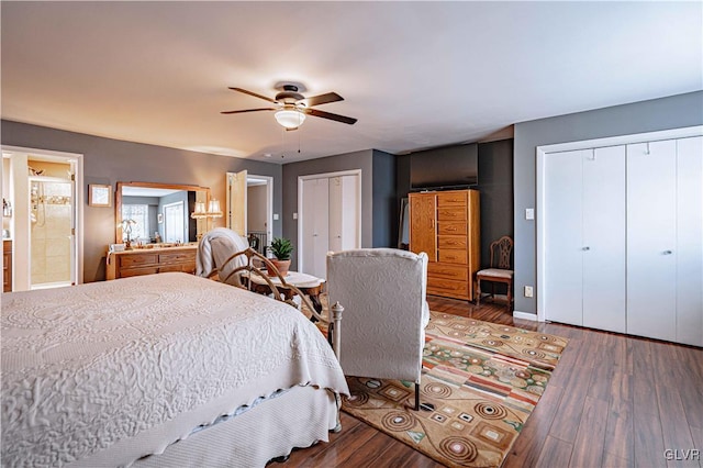 bedroom featuring multiple closets, hardwood / wood-style floors, and ceiling fan