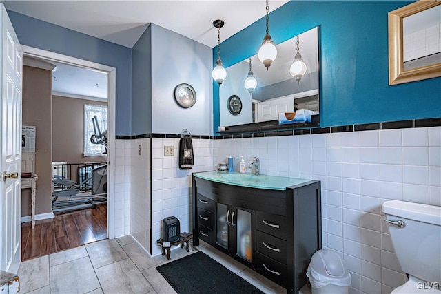 bathroom with tile walls, vanity, tile patterned floors, and toilet