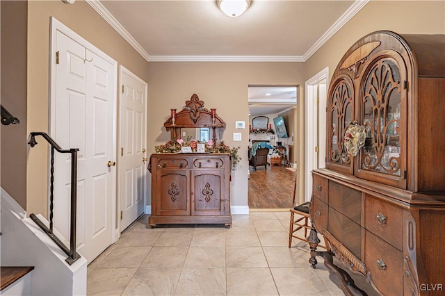 entryway with light tile patterned flooring and ornamental molding