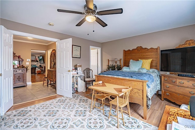 bedroom featuring ornamental molding, ceiling fan, and light hardwood / wood-style flooring