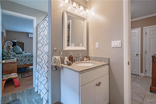 bathroom with vanity, hardwood / wood-style floors, and crown molding