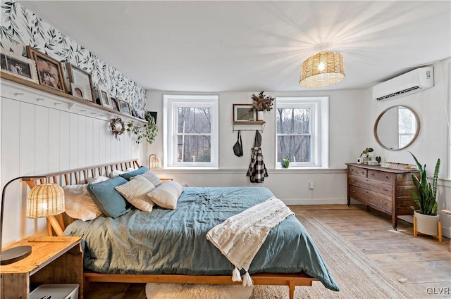 bedroom featuring light wood-type flooring and a wall unit AC