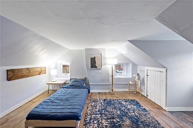 bedroom featuring hardwood / wood-style flooring and vaulted ceiling