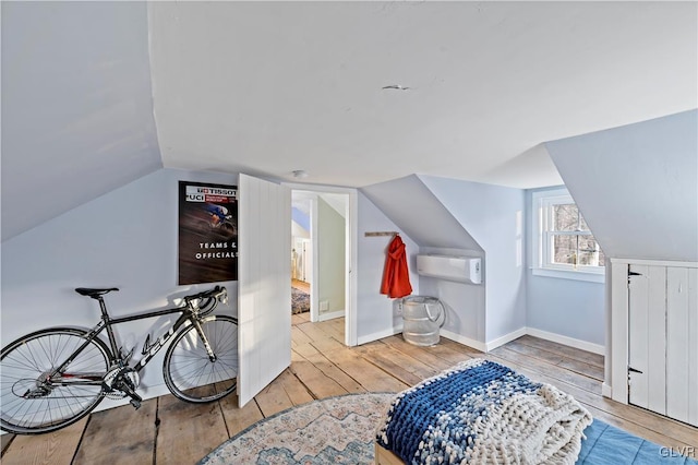 additional living space featuring wood-type flooring and lofted ceiling