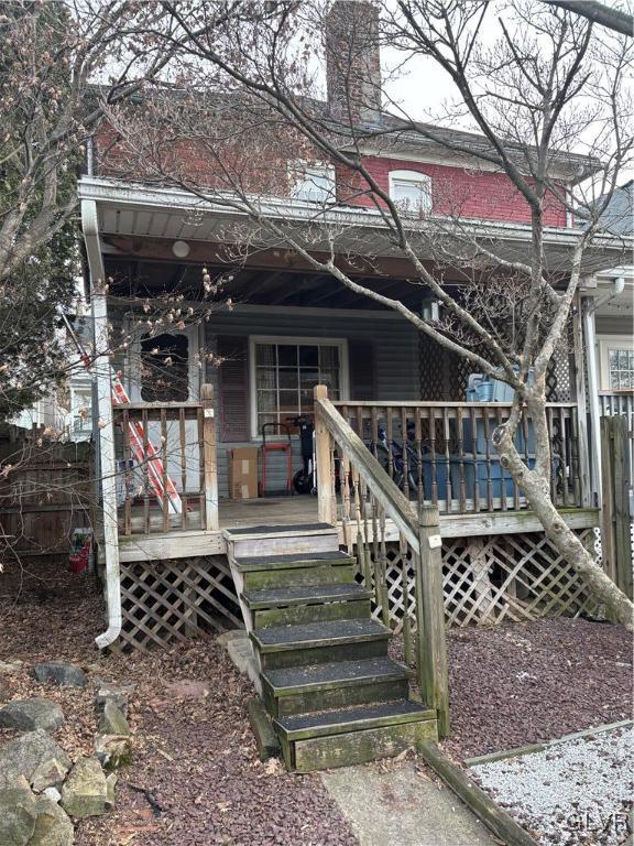 back of property featuring covered porch