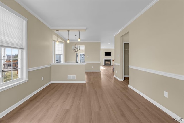 interior space featuring ornamental molding, wood-type flooring, and a wealth of natural light