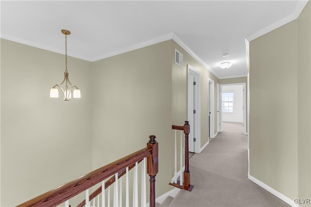 corridor with ornamental molding, light carpet, and an inviting chandelier