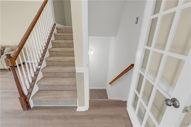 staircase with hardwood / wood-style floors