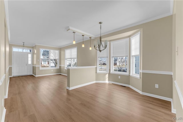 unfurnished dining area featuring ornamental molding, a chandelier, and light hardwood / wood-style flooring