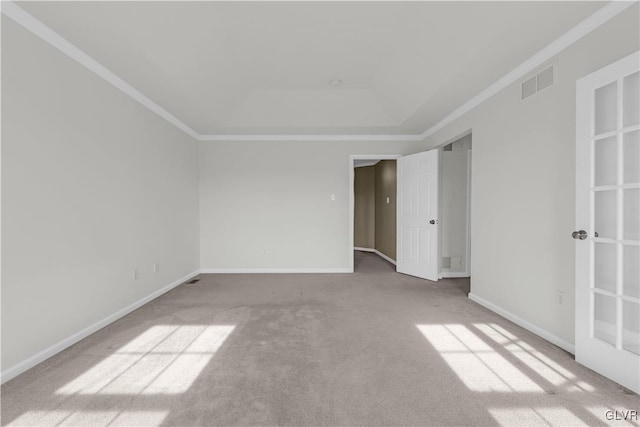 unfurnished room featuring crown molding, a tray ceiling, and carpet floors