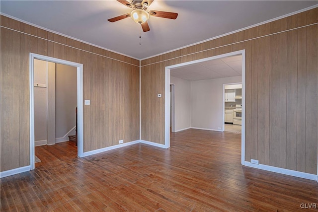 spare room with hardwood / wood-style floors, ceiling fan, and wood walls