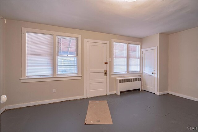 foyer featuring radiator and plenty of natural light