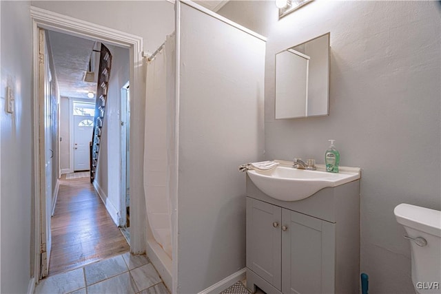 bathroom featuring vanity, toilet, and curtained shower