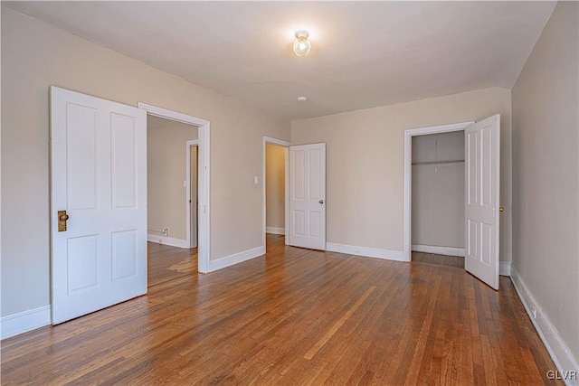 unfurnished bedroom featuring dark hardwood / wood-style flooring and a closet