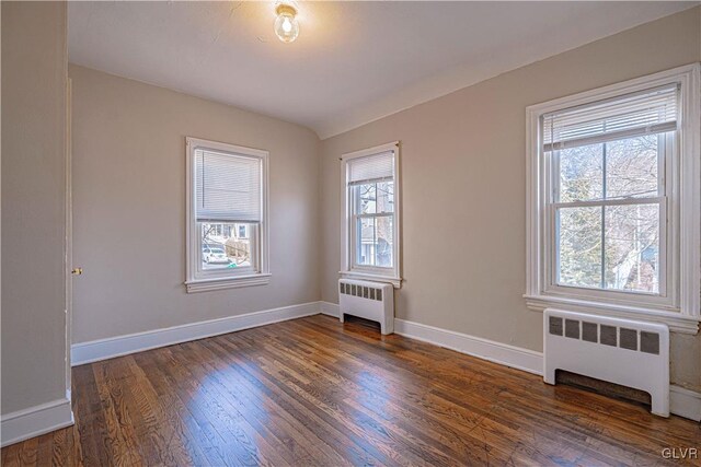 unfurnished room with dark wood-type flooring and radiator