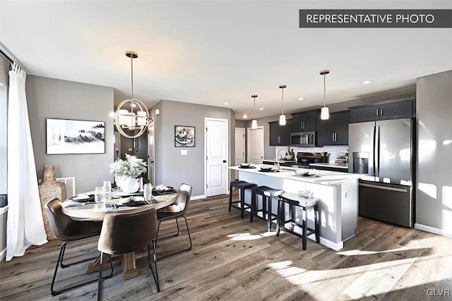 dining room with sink, a chandelier, and dark hardwood / wood-style flooring