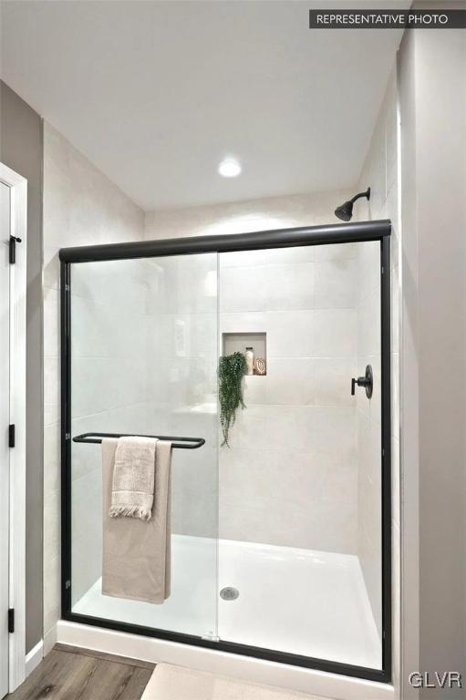 bathroom featuring walk in shower and wood-type flooring