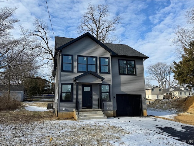 view of front of property with a garage and cooling unit