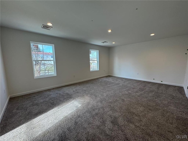 spare room with dark colored carpet