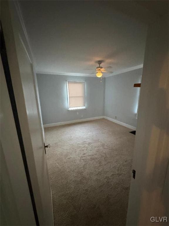 carpeted spare room featuring crown molding and ceiling fan