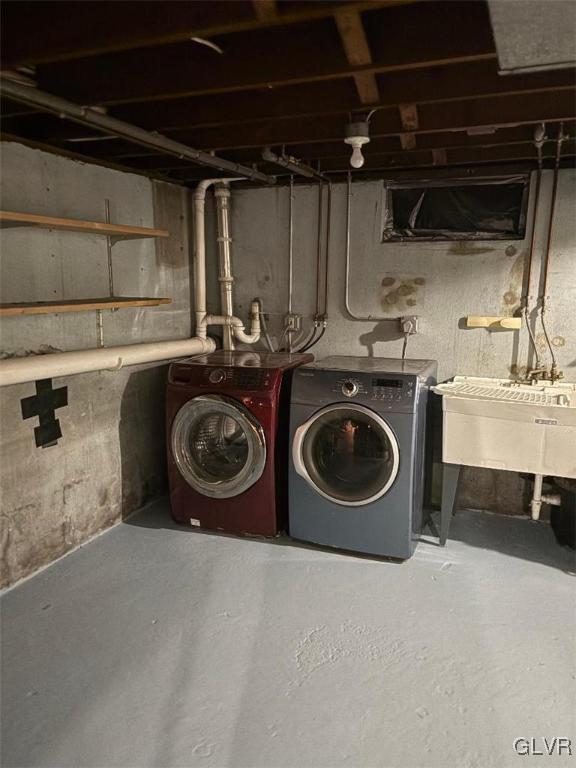 basement featuring washer and clothes dryer and sink