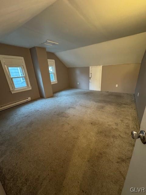 additional living space featuring carpet floors, a baseboard radiator, and lofted ceiling