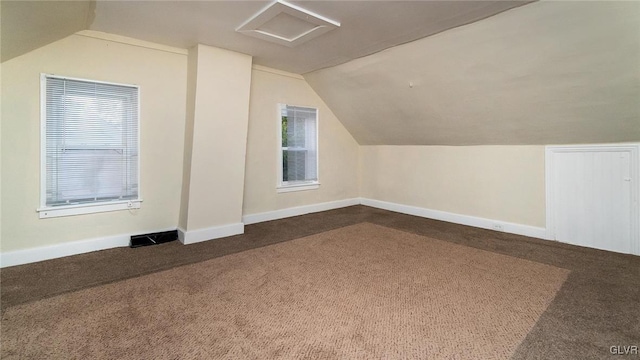 bonus room featuring vaulted ceiling and dark carpet