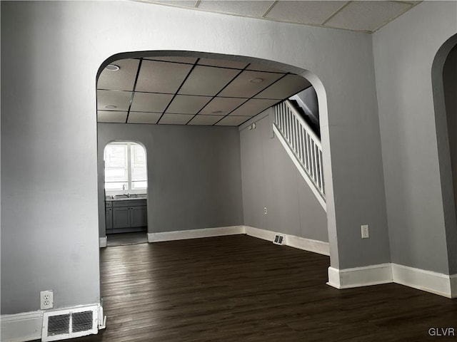 interior space with sink, a paneled ceiling, and dark hardwood / wood-style floors