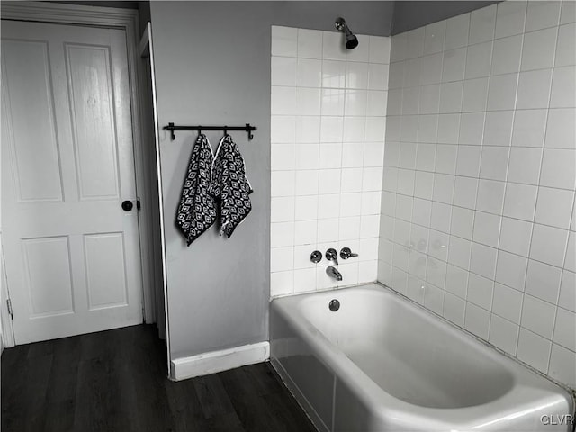 bathroom with wood-type flooring and tiled shower / bath