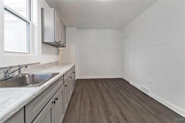 kitchen featuring gray cabinetry, sink, and a wealth of natural light