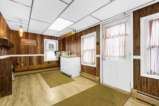 kitchen featuring a baseboard radiator and wood walls