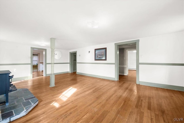 unfurnished living room with hardwood / wood-style flooring and a wood stove