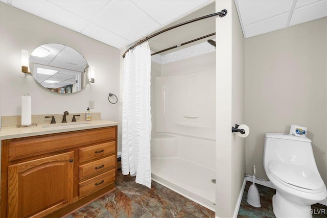 bathroom with vanity, curtained shower, a paneled ceiling, and toilet