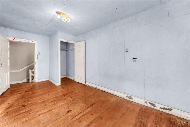 unfurnished bedroom with light wood-type flooring and a closet