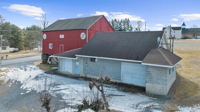 view of snow covered exterior with a garage