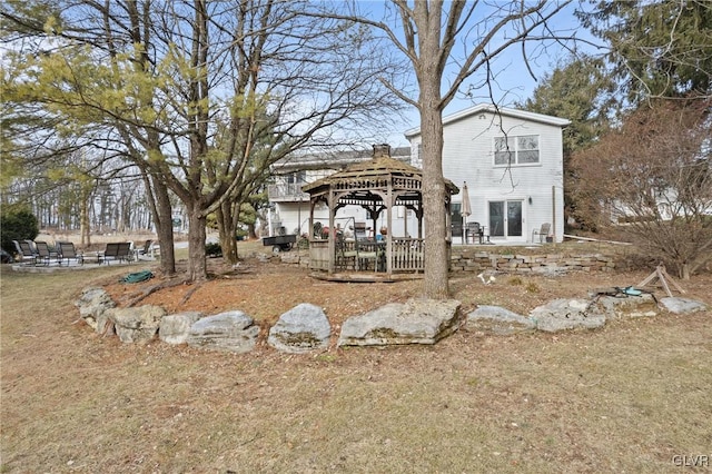 back of house with a gazebo and a yard