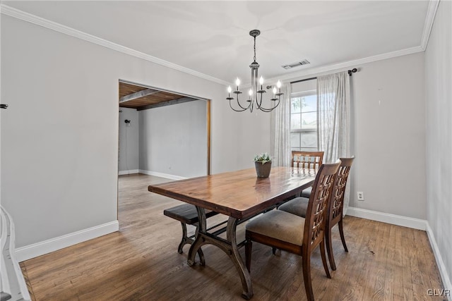 dining area with an inviting chandelier, hardwood / wood-style flooring, and ornamental molding