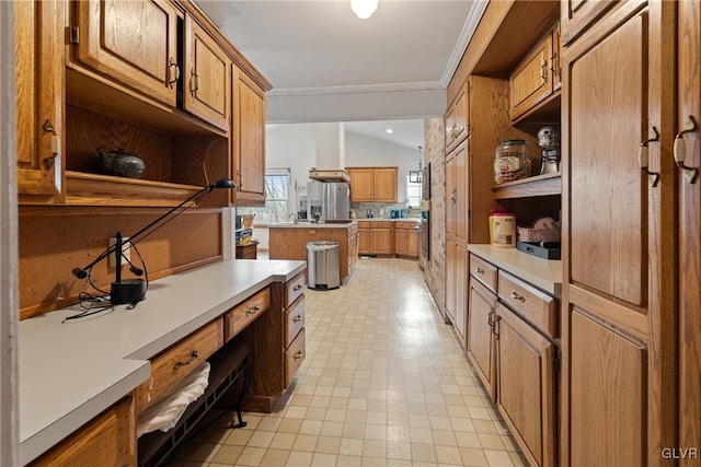 kitchen featuring ornamental molding, lofted ceiling, and stainless steel fridge