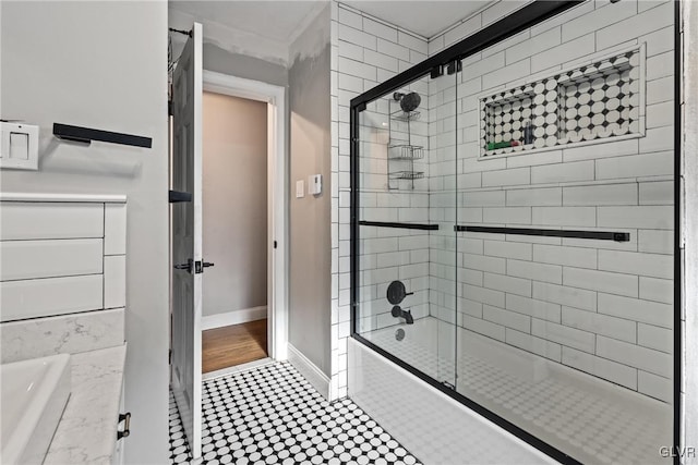 bathroom featuring tile patterned flooring, bath / shower combo with glass door, and vanity